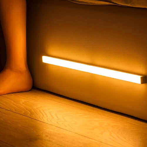 USB rechargeable LED sensor light bar mounted under a cabinet, emitting bright white light with a sleek modern design