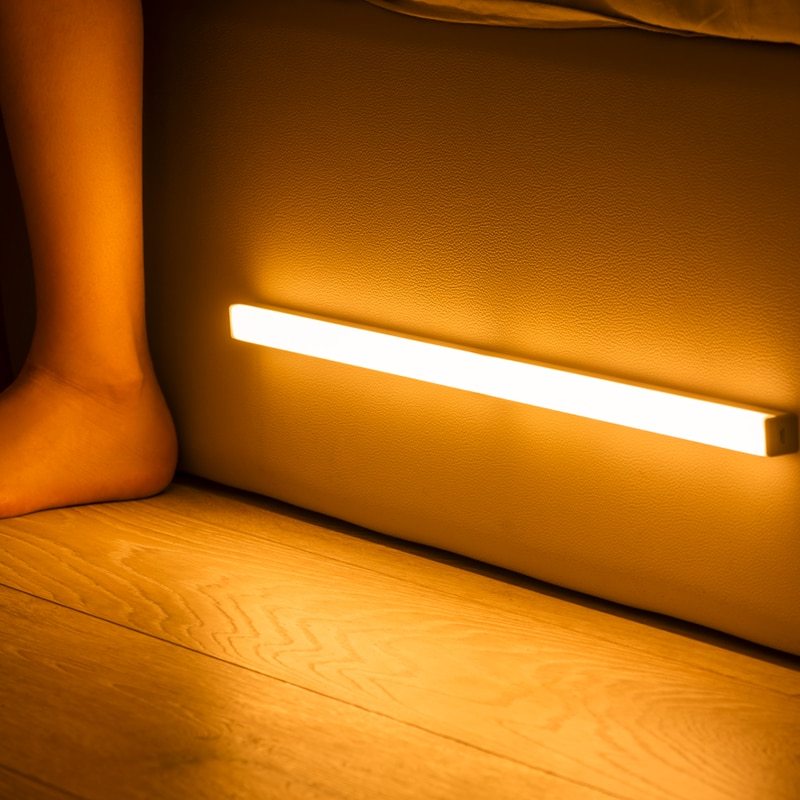 USB rechargeable LED sensor light bar mounted under a cabinet, emitting bright white light with a sleek modern design
