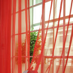 Modern tulle sheer curtains hanging in a bright living room and bedroom, allowing natural light to filter through softly