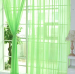 Modern tulle sheer curtains hanging in a bright living room and bedroom, allowing natural light to filter through softly