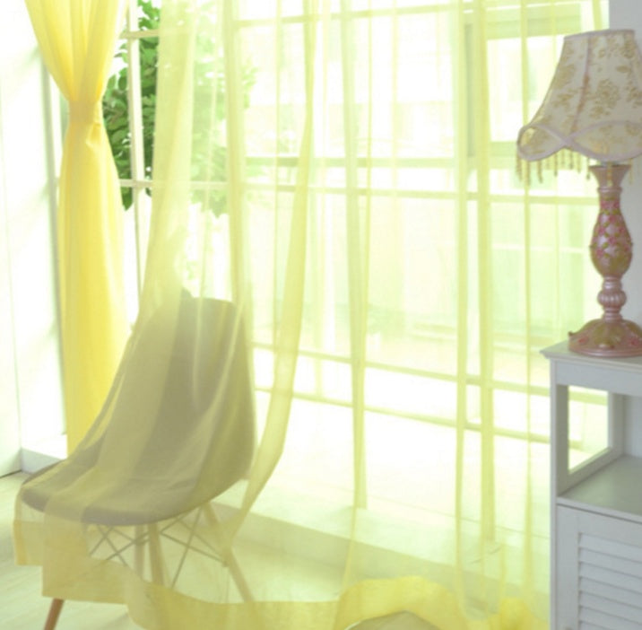 Modern tulle sheer curtains hanging in a bright living room and bedroom, allowing natural light to filter through softly