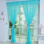 Modern tulle sheer curtains hanging in a bright living room and bedroom, allowing natural light to filter through softly