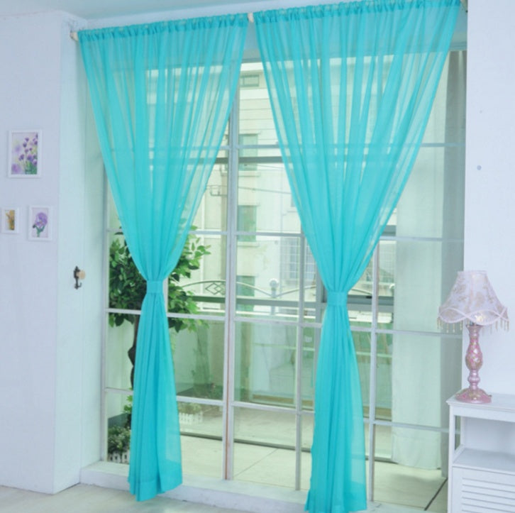 Modern tulle sheer curtains hanging in a bright living room and bedroom, allowing natural light to filter through softly