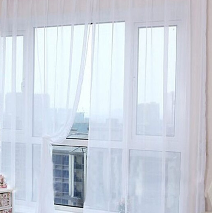 Modern tulle sheer curtains hanging in a bright living room and bedroom, allowing natural light to filter through softly