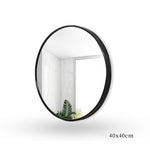 Round black aluminum Curve Culture vanity mirror with 40x40 cm size, reflecting a minimalist bathroom with natural light.
