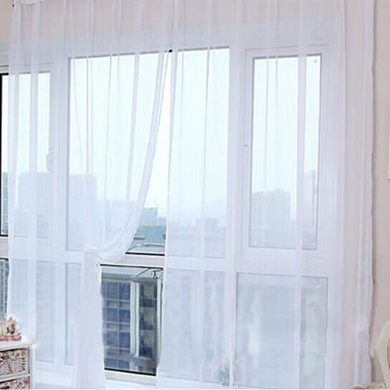 Modern tulle sheer curtains hanging in a bright living room and bedroom, allowing natural light to filter through softly