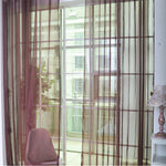 Modern tulle sheer curtains hanging in a bright living room and bedroom, allowing natural light to filter through softly
