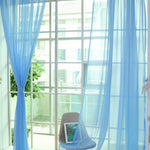Modern tulle sheer curtains hanging in a bright living room and bedroom, allowing natural light to filter through softly