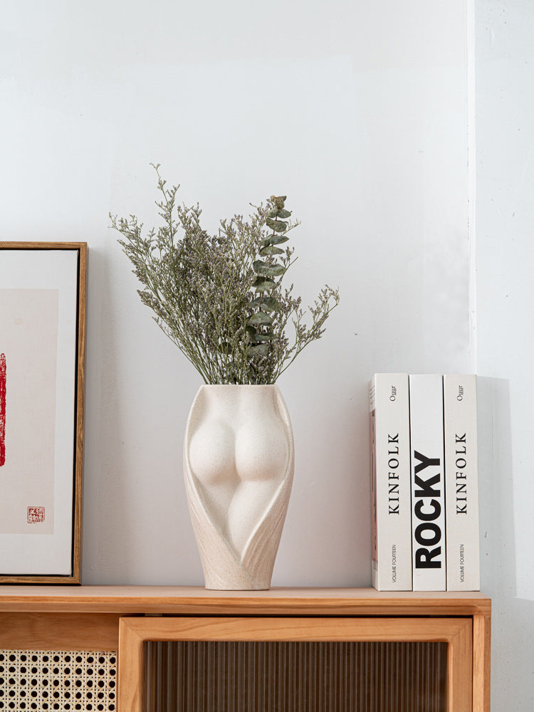 Modern ceramic flower vase with sculpted body design, styled with dried greenery on a wooden shelf for contemporary interiors.
