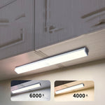 USB rechargeable LED sensor light bar mounted under a cabinet, emitting bright white light with a sleek modern design