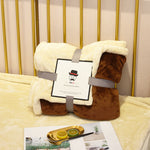 Soft flannel fleece blanket draped over a sofa and bed, providing warmth and cozy comfort for home use