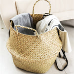 Portable seagrass woven flower storage basket with handles, used for organizing items or displaying plants in natural home decor style