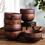 Ethnic wooden bowl with intricate carved patterns, showcasing traditional craftsmanship and rustic decorative style