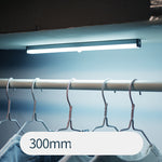 USB rechargeable LED sensor light bar mounted under a cabinet, emitting bright white light with a sleek modern design