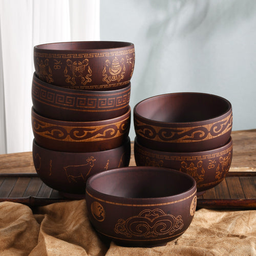 Ethnic wooden bowl with intricate carved patterns, showcasing traditional craftsmanship and rustic decorative style