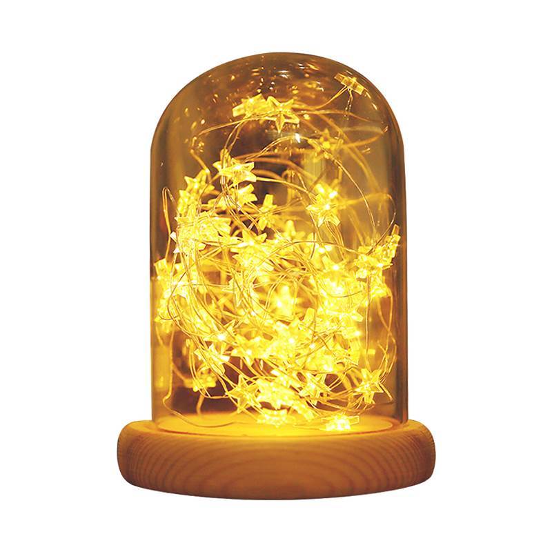 Golden-hued Atmosphere LED Night Lamp with star-shaped lights in a glass dome and wooden base. Ideal for dreamy bedroom or festive decor.