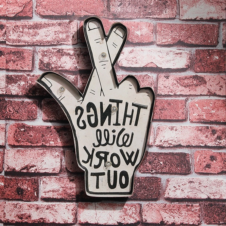 Shapeable LED neon wall decor featuring a hand with crossed fingers and motivational text, mounted on a brick wall background.